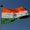 The Indian national flag waves proudly against a clear blue sky, symbolizing unity and pride.